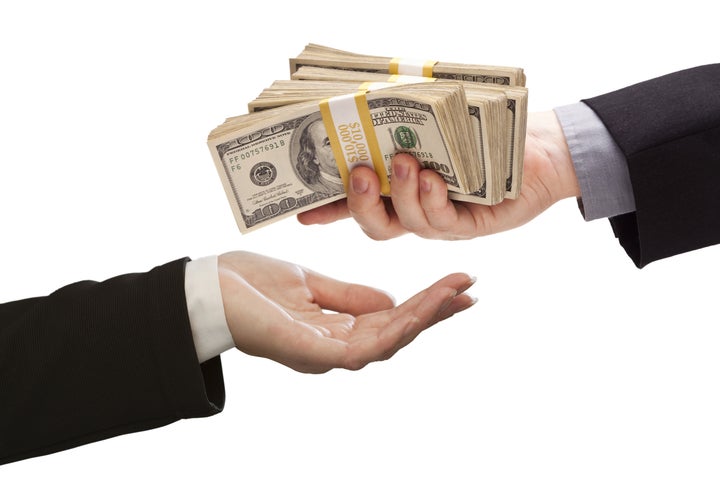 Handing Over Stacks of Cash to Other Hand Isolated on a White Background.