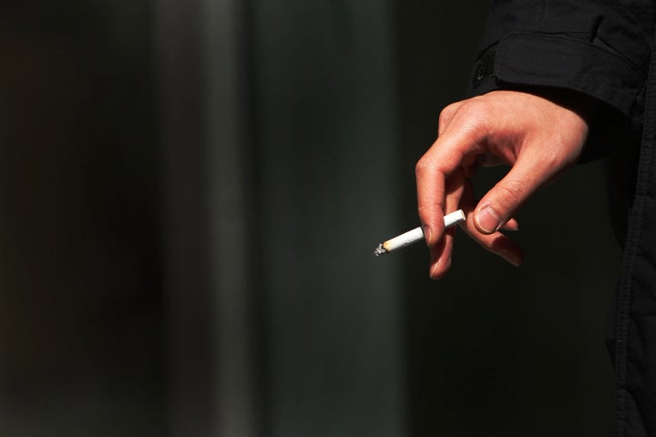 NEW YORK - MARCH 30: A woman smokes a cigarette March 30, 2009 in New York City. On April 1 a new federal excise tax on tobacco will officially commence, driving the per-pack tax from 39 cents to $1.01.The tax will affect all tobacco products, including cigars and pipes, and the money earned will be used to expand health coverage for low-income children. (Photo by Spencer Platt/Getty Images)