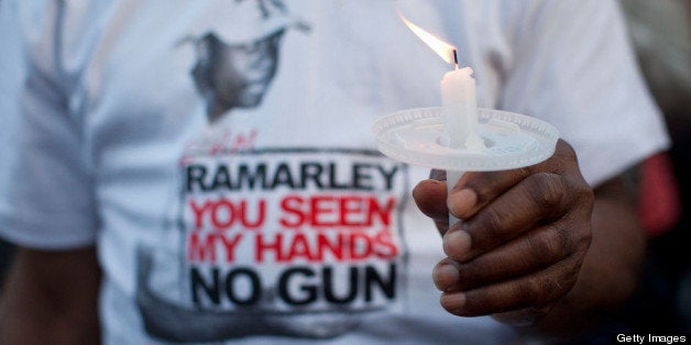 NEW YORK, NY - MARCH 22: A woman holds a candle during a vigil for Ramarley Graham outside New York City Police Department's
