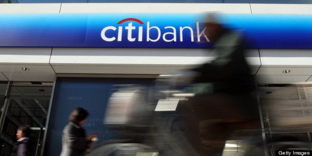 Pedestrians walk past a Citibank branch while a man cycles past in Tokyo, Japan, on Tuesday, Jan. 18, 2011. Citigroup Inc. is expected to announce earnings today. Photographer: Tomohiro Ohsumi/Bloomberg via Getty Images