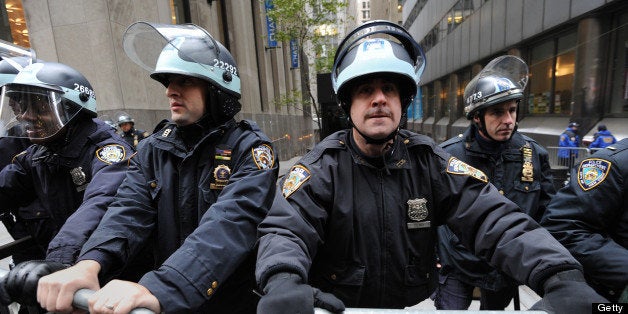 New York Police Department officers with riot helmets man a barricade at Broadway and Exchange Street, a few blocks from the New York Stock Exchange as demonstrators with 'Occupy Wall Street' mark the two month anniversary of the protest November 17, 2011 in New York. Some 1,000 protesters converged on Wall Street Thursday, and fights erupted outside the New York Stock Exchange amid a tense face-off with police. Demonstrators scuffled with men in business suits trying to push their way through the throngs on the way to work at the start of a day of protests in a show of force by the Occupy Wall Street movement. AFP PHOTO/Stan HONDA (Photo credit should read STAN HONDA/AFP/Getty Images)