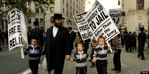 A man and a few boys walk toward a protest of the Alliance of American Jews in protest against the Israeli Draft June 9, 2013 in New York. Thousands gathered in Federal Plaza to demonstrate against being drafted by the government of Israel. AFP PHOTO/Don Emmert (Photo credit should read DON EMMERT/AFP/Getty Images)