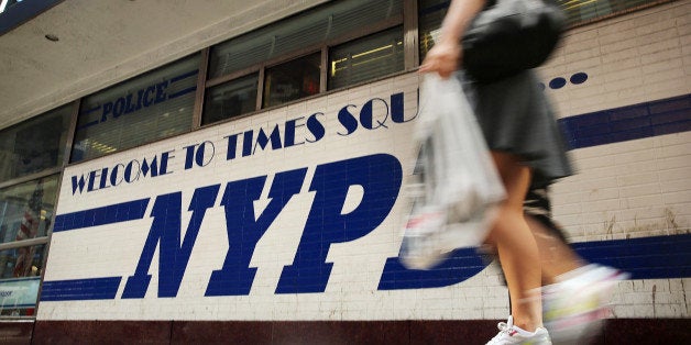 NEW YORK, NY - AUGUST 12: A woman walks by a New York Police Department (NYPD) outpost in Times Square on August 12, 2013 in