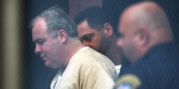 NORWALK, CT - AUGUST 28: Michael Skakel (C) leaves Superior Court in handcuffs after the first day of his sentencing hearing August 28, 2002 in Norwalk, Connecticut. Skakel was convicted of the 1975 slaying of childhood friend Martha Moxley in June. (Photo by Beth Keiser-Pool/Getty Images)