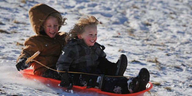 DENVER, CO - DECEMBER 29, 2013: Jonas Antonson, 4, in front and his brother Henry, 6, scream with delight as they fly down one of the many sledding hills at Ruby Hill Park in Denver, Co on December 29, 2013. Despite the lack of snow, kids still enjoyed the sledding at the park. (Photo By Helen H. Richardson/ The Denver Post)