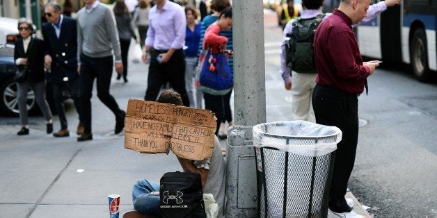 A homeless man with a sign asks for money on a street in New York on October 14, 2014. AFP PHOTO/Jewel Samad (Photo credit should read JEWEL SAMAD/AFP/Getty Images)