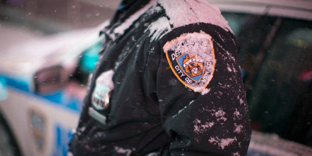 Snow accumulates on an NYPD officer in Times Square, Thursday, Jan. 2, 2014, in New York. The snow storm is expected to bring snow, stiff winds and punishing cold into the Northeast. (AP Photo/John Minchillo)