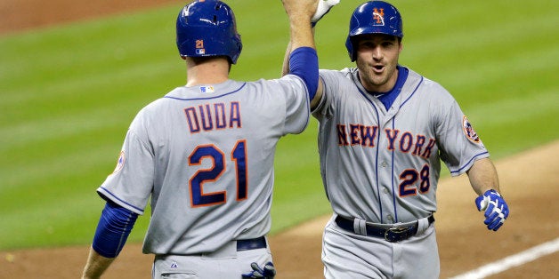 New York Mets' Daniel Murphy (28) is congratulated by teammate Lucas Duda (21), who scored after Murphy hit a three-run home run against the Miami Marlins in the ninth inning of a baseball game, Monday, April 27, 2015, in Miami. Juan Lagares also scored on the home run. The Mets won 3-1. (AP Photo/Alan Diaz)