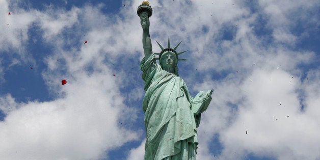 One of three helicopters showeres 1-million rose petals on the Statue of Liberty during a ceremony commemorating the 70th ann