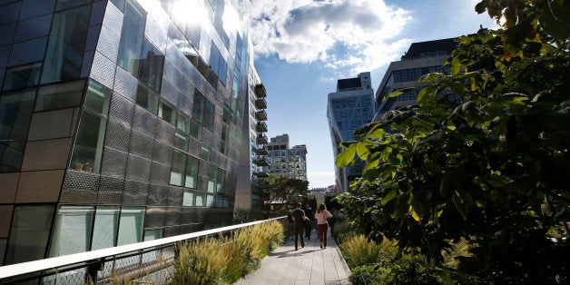 Pedestrians stroll between luxury apartment buildings along the High Line in New York, Wednesday, Sept. 17, 2014. The last stretch of the elevated walkway opens to the public Sunday, Sept. 21. (AP Photo/Kathy Willens)