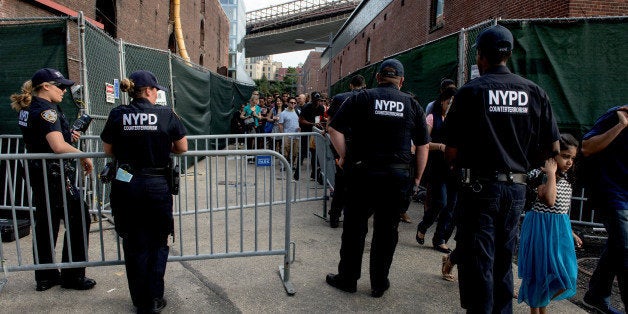 NEW YORK, NY - JULY 4: NYPD officers check bags at an entrance to Brooklyn Bridge park along the East River before the Macy's Fourth of July Fireworks on July 4, 2015 in the Brooklyn borough of New York City. An extra 7,000 NYPD officers are expected to patrol the festivities with New York City being on high alert for possible terror attacks this holiday weekend. (Photo by Andrew Renneisen/Getty Images)