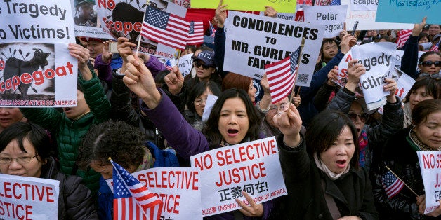 Protesters attend a rally in the Brooklyn borough of New York Saturday, Feb. 20, 2016, in support of a former NYPD police officer Peter Liang, who was convicted of manslaughter for the 2014 shooting death of Akai Gurley, in a housing project stairwell. The 28-year-old Liang, who testified the shooting was an accident, could be sentenced to 5 to 15 years for shooting Gurley, who was unarmed. (AP Photo/Craig Ruttle)