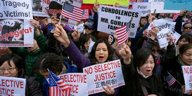 Protesters attend a rally in the Brooklyn borough of New York Saturday, Feb. 20, 2016, in support of a former NYPD police officer Peter Liang, who was convicted of manslaughter for the 2014 shooting death of Akai Gurley, in a housing project stairwell. The 28-year-old Liang, who testified the shooting was an accident, could be sentenced to 5 to 15 years for shooting Gurley, who was unarmed. (AP Photo/Craig Ruttle)