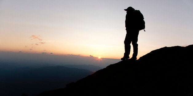 A hiker on the Appalachian Trail at sunset near Mount Clay, Located in the White Mountains, New Hampshire USA