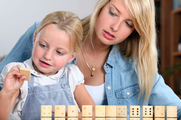 young girl playing with dominoes