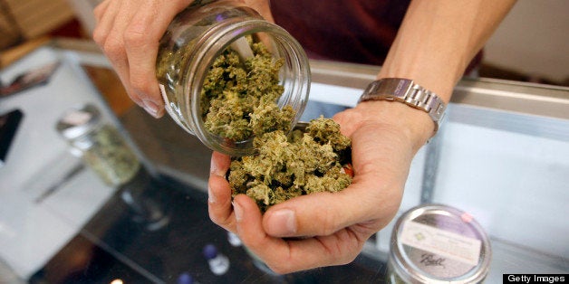 LOS ANGELES, CA - JULY 25: A budtender pours marijuana from a jar at Perennial Holistic Wellness Center medical marijuana di