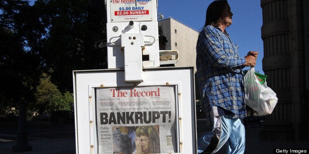 STOCKTON, CA - JUNE 27: A pedestrian walks by a Stockton Record newspaper rack displaying the headline 'Bankrupt!' on June 27, 2012 in Stockton, California. Members of the Stockton city council voted 6-1 on Tuesday to adopt a spending plan for operating under Chapter 9 bankruptcy protection following failed talks with bondholders and labor unions failed. The move will make Stockton the biggest U.S. city to file for bankruptcy protection from creditors. (Photo by Justin Sullivan/Getty Images)