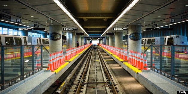 Two Bay Area Rapid Transit (BART) trains flank a closed, empty platform lined with cones while they await passengers at San Francisco International Airport.