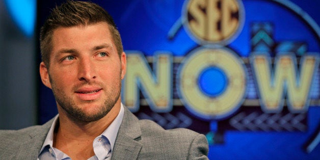 Tim Tebow ponders a question during an interview on the set of ESPN's new SEC Network in Charlotte, N.C., Wednesday, Aug. 6, 2014. Tebow has a new job as a commentator for the SEC Network, but is still looking for work in the NFL as a quarterback. (AP Photo/Chuck Burton)