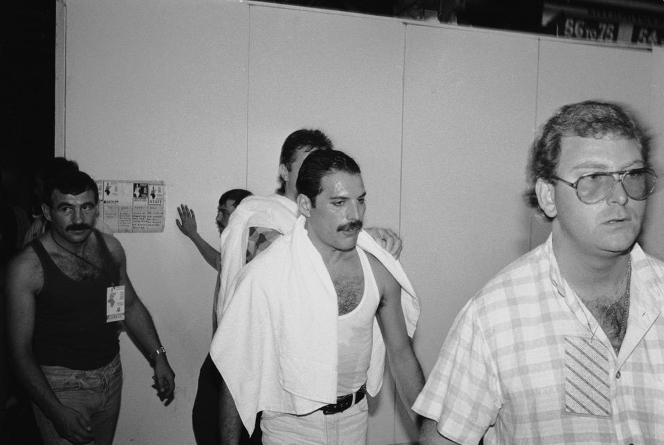 1985년 7월 13일, 잉글랜드 웸블리 스타디움에서 열린 'Live Aid' 콘서트를 앞둔 프레디 머큐리를 대기실에서 찍은 모습. 왼쪽 뒤에 검은 옷을 입고 머큐리를 따라가는 남성이 짐 허튼이다.