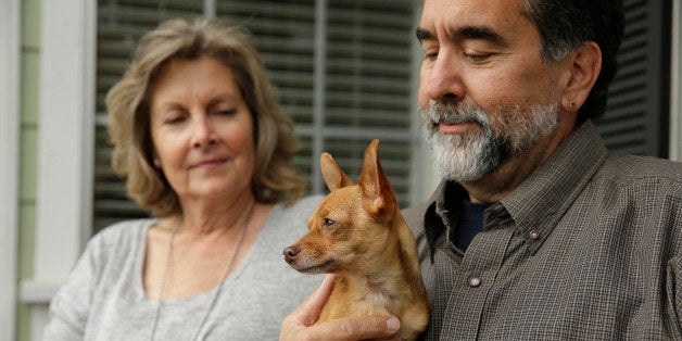 In this Monday, March 16, 2015 photo, Lynn and Tony Mazzola sit with their new dog, Lily, at their home in San Carlos, Calif.