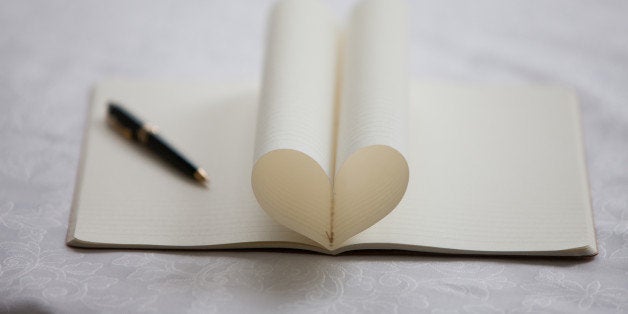 Pen and pages of notebook forming heart-shape