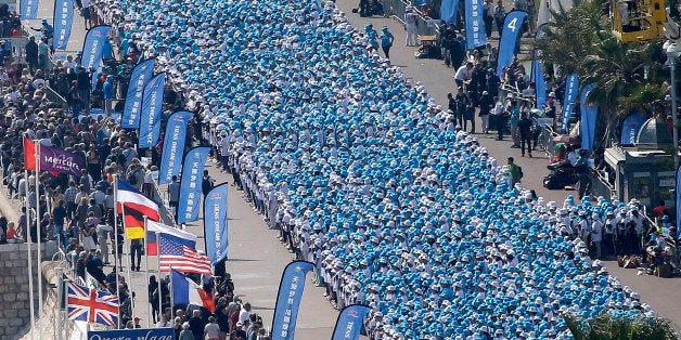 Employees of the TIENS Group, a Chinese company, attend a parade organized by CEO Li Jinyuan as part of a four-day celebration weekend for the 20th anniversary of his company, on the Promenade des Anglais, Nice, southeastern France, Friday, May 8, 2015. Li Jinyuan is sending off half his team about 6,400 employees on a two-day trip to Paris and two-day trip in Nice, France. (AP Photo/Lionel Cironneau)