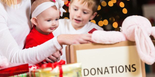 Mom with children choosing toys to donate to Christmas charity