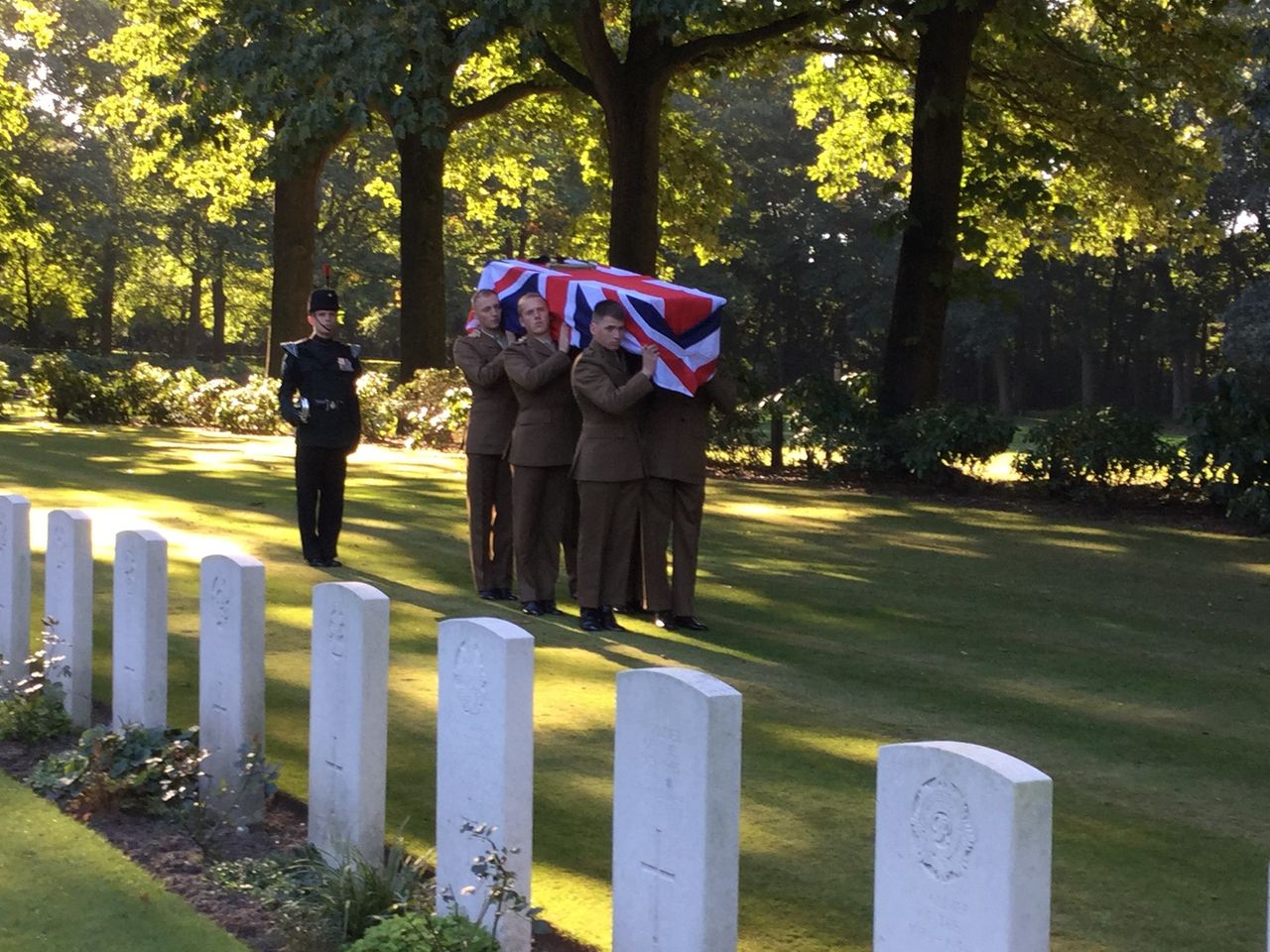 A photo of Lance Corporal Donald Noble's coffin being carried into Arnhem Oosterbeek War Cemetery by a bearer part of 5th Battalion, the Rifles 