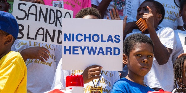 STATEN ISLAND, NEW YORK, NY, UNITED STATES - 2016/07/17: Rally participants hold signs near the site of Eric Garner's death. On the second anniversary of the death of Eric Garner during his attempted arrest by NYPD officer Daniel Pantaleo, Black Lives Matter coalition members and supporters gathered at the site of his death on Bay Street and then marched on to the 120th Precinct of the NYPD intermittently practicing civil disobedience as NYPD Community Affairs officers attempted to regulate the march, in Tompkinsville, Staten Island. (Photo by Albin Lohr-Jones/Pacific Press/LightRocket via Getty Images)