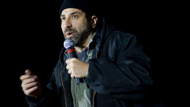 Description 1 Comedian Dave Attell performs during the 2009 USO Holiday Tour stop in Kandahar, Afghanistan, Dec. 17, 2009. | ... 