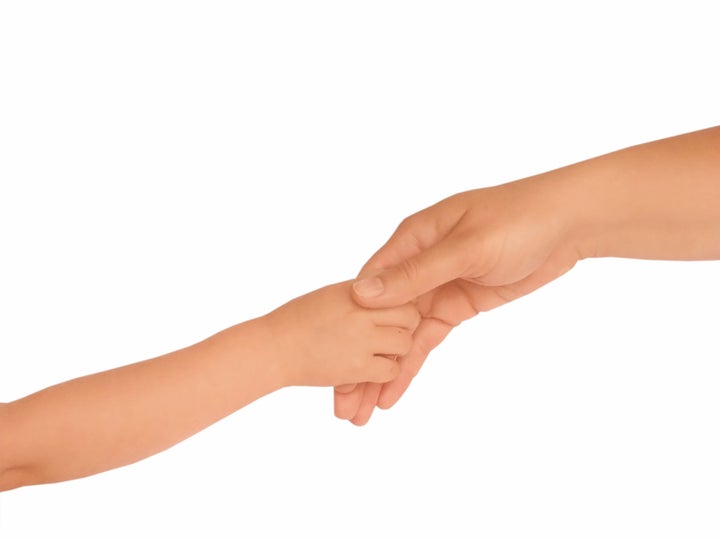 Adult and child hold hands