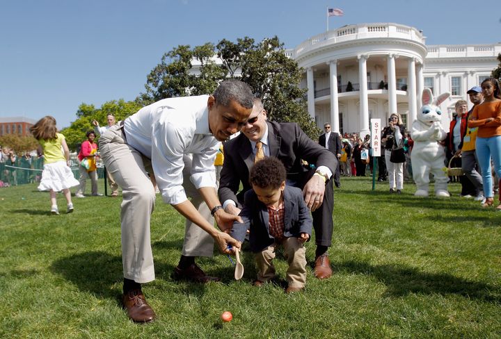 WASHINGTON, DC - APRIL 09: U.S. President Barack Obama (L) helps a young participant roll an egg during the White House Easter Egg Roll on the South Lawn of the White House on April 9, 2012 in Washington, DC. Thousands of people people are expected to attend the 134-year-old tradition of rolling colored eggs down the White House lawn that was started by President Rutherford B. Hayes in 1878. (Photo by Chip Somodevilla/Getty Images)
