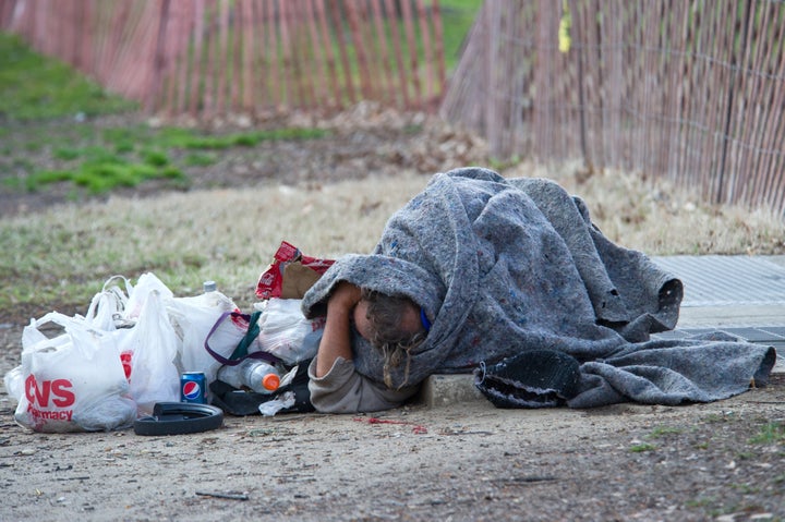 This image taken March 13, 2013 in Washington, DC, shows a homeless man sleeping on a grate for warmth. AFP PHOTO / Karen BLEIER (Photo credit should read KAREN BLEIER/AFP/Getty Images)