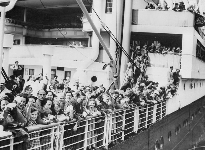 A crowd of Jewish refugees aboard the MS St. Louis ocean liner wave as they arrive in Antwerp, Belgium, after being denied re