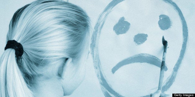 Girl (5-7) painting picture of sad face in classroom (Toned B&W)