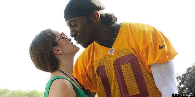 ASHBURN, VA - JULY 26: Robert Griffin III #10 of the Washington Redskins kisses his fiancee Rebecca Liddicoat as he walks off the field during training camp at Redskins Park on July 26, 2012 in Ashburn, Virginia. (Photo by Patrick McDermott/Getty Images)