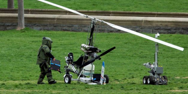 A member of a bomb squad checks a small helicopter after a man landed on the West Lawn of the Capitol in Washington, Wednesday, April 15, 2015. Police arrested a man who steered his tiny, one-person helicopter onto the West Lawn of the U.S. Capitol Wednesday, astonishing spring tourists and prompting a temporary lockdown of the Capitol Visitor Center. Capitol Police didn't immediately identify the pilot or comment on his motive, but a Florida postal carrier named Doug Hughes took responsibility for the stunt on a website where he said he was delivering letters to all 535 members of Congress in order to draw attention to campaign finance corruption. (AP Photo/Manuel Balce Ceneta)