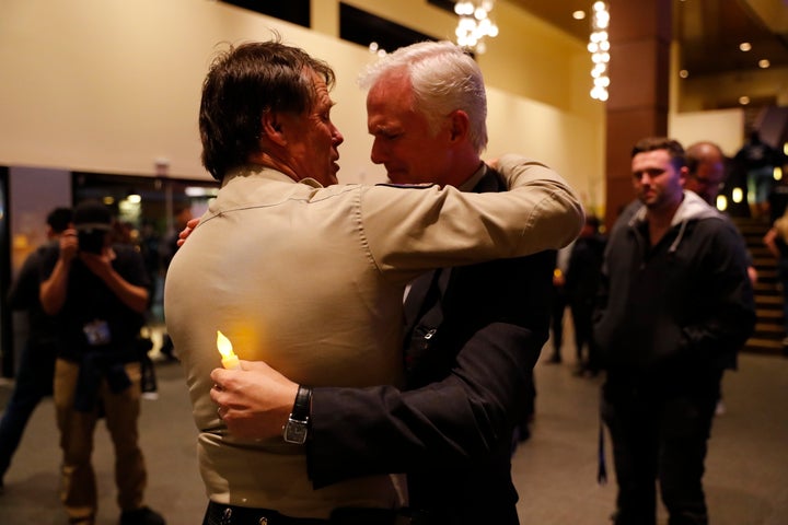 Thousand Oaks Police Chief Tim Hagel, left, hugs Officer Chris Dunn at the vigil.