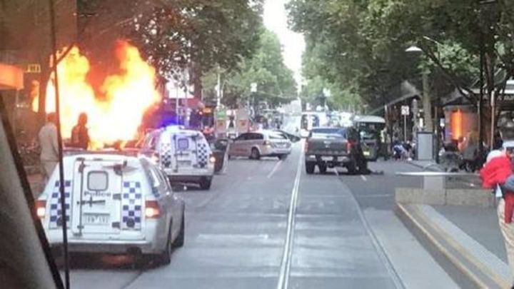A car was seen ablaze in a central Melbourne street on Friday after a man stabbed several people.