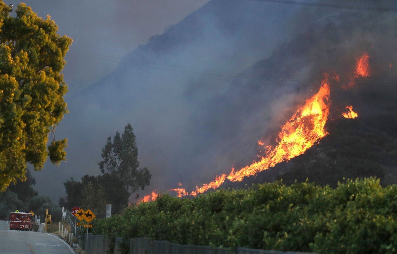 A wildfire comes down from a hilltop near Newbury Park, Calif., on Nov. 8.