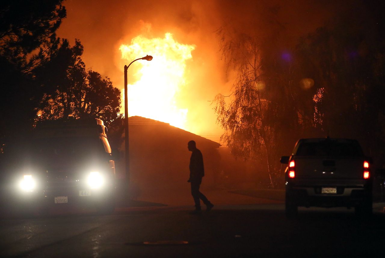 November 9, 2018; Oak Park, CA; A neighbor walks by a house on fire on Lafitte Dr. in Oak Park, November 9, 2018.Mandatory Credit: Jay Calderon/The Desert Sun/Sipa USA