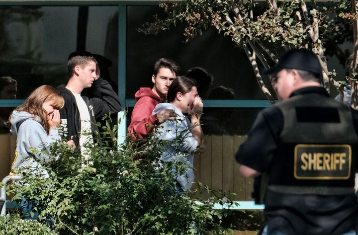 Grieving people are led into the Thousand Oaks Teen Center where families have gathered after a deadly shooting at a bar on Nov. 8 in Thousand Oaks, California.