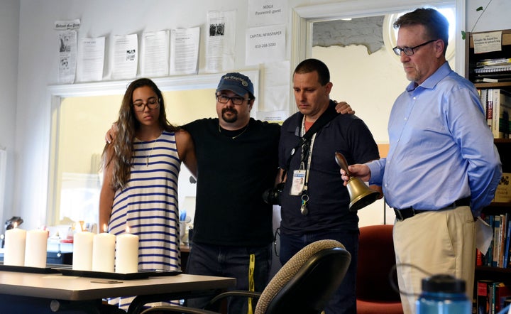 Rick Hutzell, right, the editor of The Capital Gazette, is joined by reporter Selene San Felice and photojournalists Paul W. Gillespie, center, and Joshua McKerrow as he rings a bell during a moment of silence July 5 in Annapolis, Maryland.