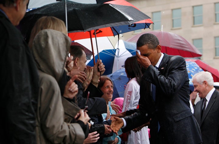 Barack Obama wipes the rain off his face as he meets Pentagon staff and family members of the victims of the September 11 attacks in a ceremony marking the eighth anniversary of the tragedy at the Pentagon in 2009.