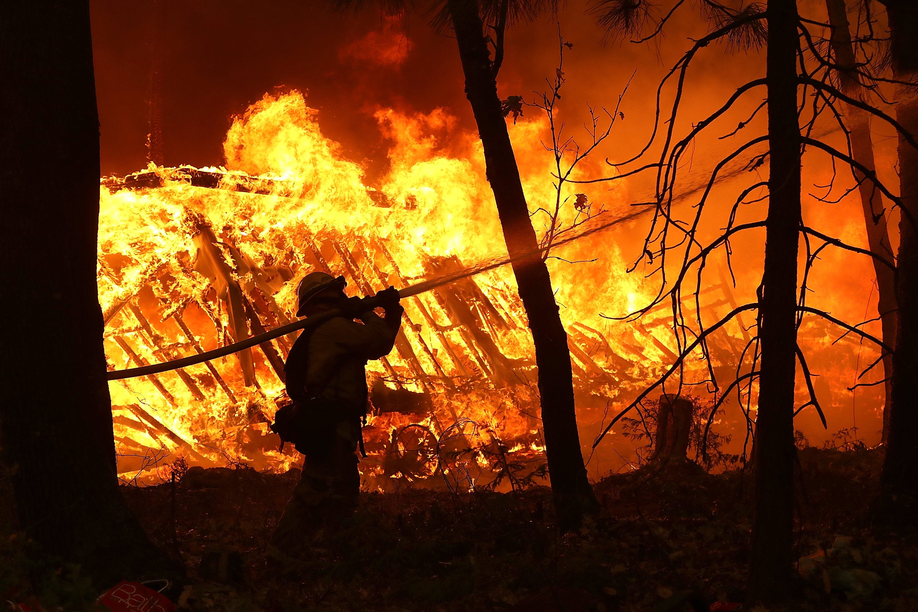 Firefighters work in dangerous conditions to fight the fast-moving fires in northern and southern California