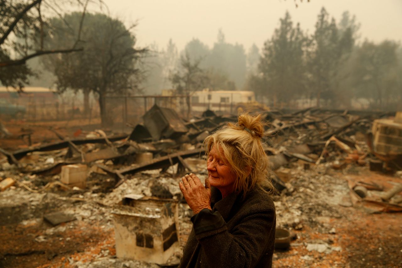 Cathy Fallon stands near the charred remains of her home in Paradise, Calif.