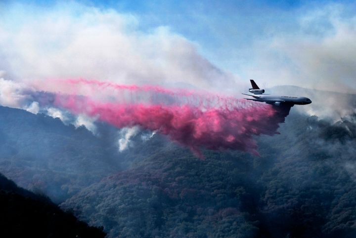 A jet drops fire retardant in the mountains near Malibu Canyon Road, Malibu