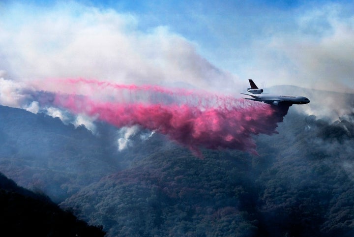 A jet drops fire retardant in the mountains near Malibu Canyon Road, Malibu