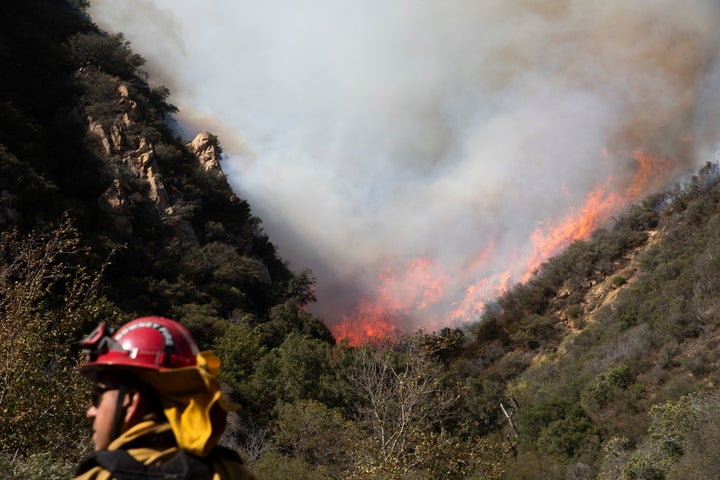 Firefighters survey a hillside blaze